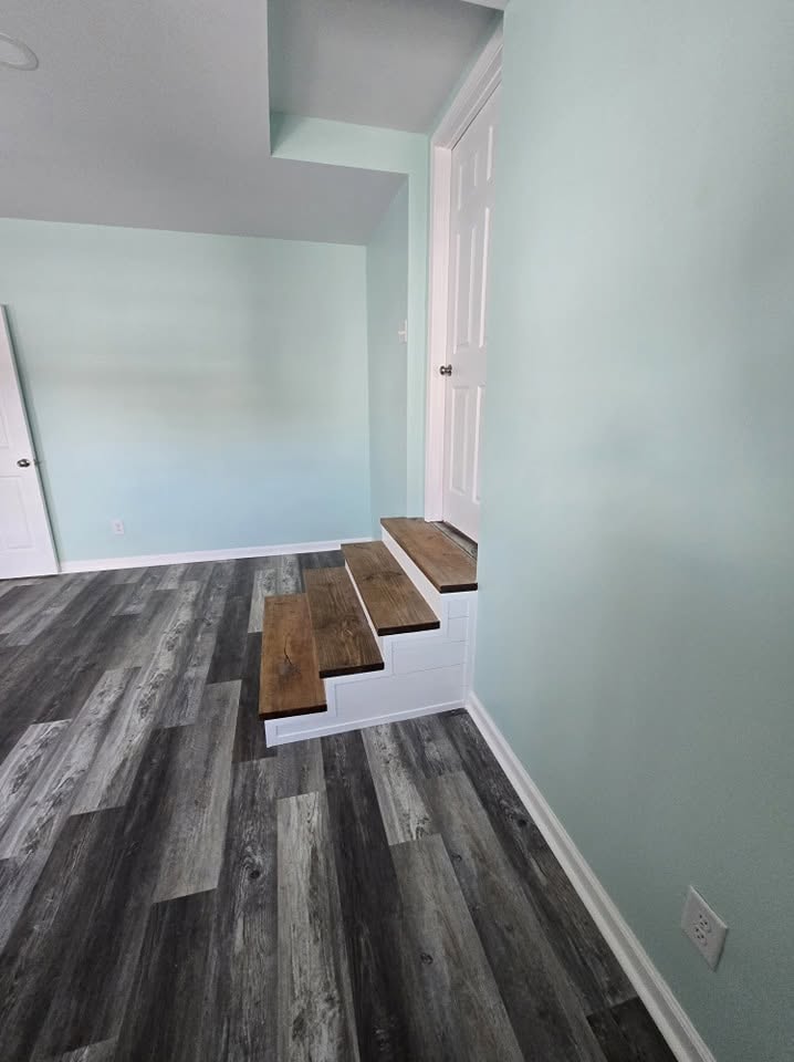 Gray luxury vinyl plank flooring with wood stair treads