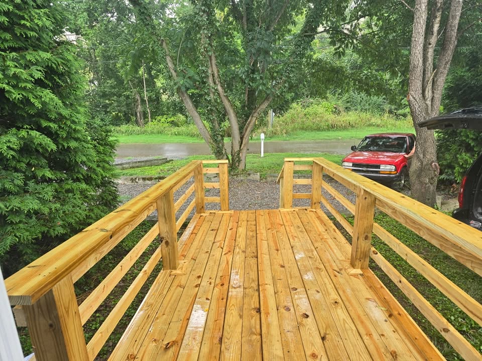 Wood deck with railings overlooking a tree-lined yard